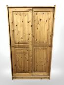 A pair of modern pine sliding door wardrobes,