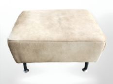 A cow hide upholstered footstool on aluminium legs