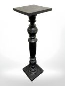 An ebonised torchere, height 107 cm.