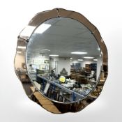 An Art Deco two tone peach glass circular wall mirror,