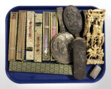 A group of boxed oriental hand fans, continental embossed white metal compact,