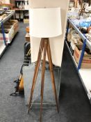 A tripod standard lamp and a un-framed mirror,