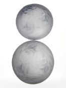 A pair of Art Deco blue frosted glass circular light shades depicting flowers in relief,