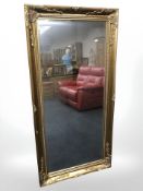 A reproduction gilt bevelled mirror, 159 cm x 78 cm.