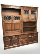 A reproduction oak linen fold sideboard with leaded glass doors,
