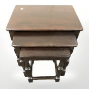 A reproduction oak nest of three tables,