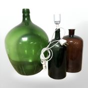 A green glass carboy, a bottle converted to a lamp and a further bottle, tallest 42 cm.