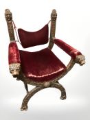 A 19th century continental heavily carved oak X-frame armchair with lion mask arm rests, 75 cm wide.