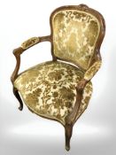 A continental carved beech salon armchair in gold upholstery.