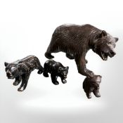 A 20th century black forest bear and three cubs, largest 13 cm long.