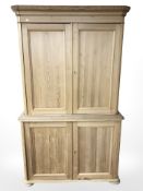 An early 20th century pine double door pantry cupboard on bun feet,