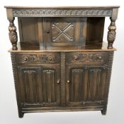 A heavily carved oak linen fold court cupboard,
