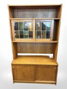 A teak sliding door bookcase with stained and leaded glass doors, 100 cm x 42 cm x 171 cm.