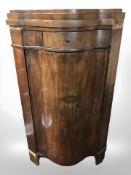 A 19th century continental mahogany serpentine front corner cupboard,