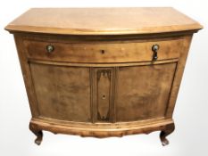 A reproduction burr walnut bow-front side cabinet,