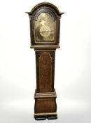 A 20th century continental oak longcase clock with gilded decoration, with pendulum and weights,