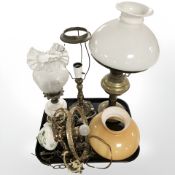A brass oil lamp with opaque shade,