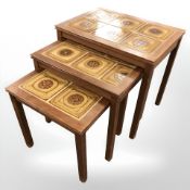 A Danish teak tile inset nest of three tables, width 53 cm.