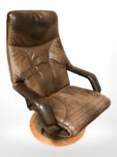 A contemporary Danish stitched brown leather swivel lounge armchair.