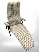 A Scandinavian metal framed folding lounger chair in chequered fabric.