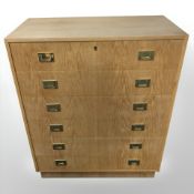 A 20th century oak veneered six drawer chest, with brass drop handles,