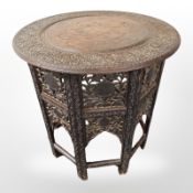 A 19th century Anglo Indian heavily carved and brass inlaid circular occasional table,