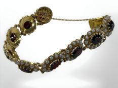 A gilded metal panel bracelet set with seed pearls and garnets.