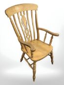 A pine farmhouse-style armchair.