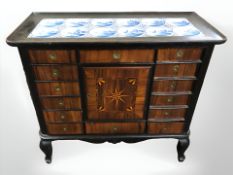 A 19th century Dutch inlaid walnut side cabinet, with blue and white delft tiles inset to top,