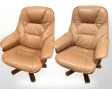 A pair of Danish tan leather swivel armchairs on bentwood supports