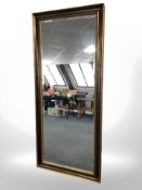A large reproduction floor standing gilt framed mirror, 186 cm x 80 cm.