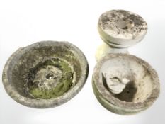 A concrete pedestal circular birdbath, tripod planter and a small figure of a bird.