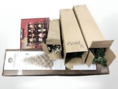 A group of artificial christmas trees and boxed decorations.