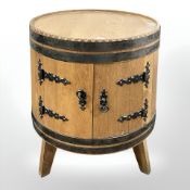 An oak barrel double door cabinet, with ironwork fittings, height 62 cm.