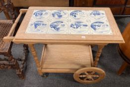 A 20th century Dutch oak trolley with delft tiles inset to top, length 82 cm.