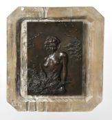 A patinated metal panel depicting a nude female in wooden surround, 50 cm x 43 cm.
