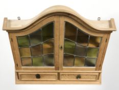 A 20th century Danish blond oak wall cabinet with stained and leaded glass doors,