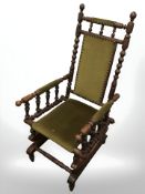 A bobbin turned rocking chair in studded draylon fabric.