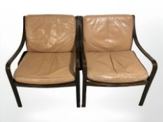A pair of contemporary Danish stained bentwood lounge armchairs with tan leather cushions,