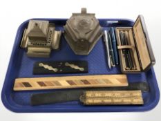 A hammered copper inkwell, further brass example, several rules, pens, including Parker.