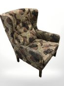 A 20th century Danish wing back armchair in button floral upholstery