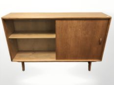 A 20th century teak sliding glass door low bookcase, designed by Herbet E.