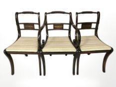 A set of eight mahogany and brass inlaid regency style dining chairs.