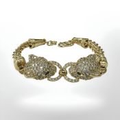 A gold plated bracelet with encrusted cat head terminals,