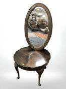 An Edwardian oak oval mirror,