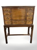 A reproduction mahogany fall front drink's cabinet in George III style fitted dummy drawers to