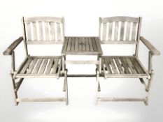 A teak two seater garden bench, incorporating a central table, 155 cm wide.