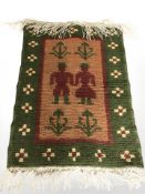 A Dutch pictorial woolen rug depicting two figures, 84 cm x 50 cm.