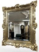 A reproduction gilt resin bevelled mirror, 70 cm x 60 cm.