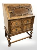 A 1920's carved oak fall front bureau,